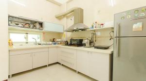 花蓮市にある相遇民宿Encounter Hostel - 證號 2153-附車位-English welcomeの白いキャビネットとステンレス製の冷蔵庫を備えたキッチン
