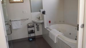 a bathroom with a bath tub and a sink at Bass Coast Country Cottages in Bass
