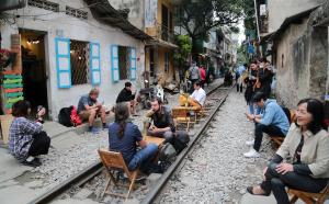 un grupo de personas sentadas en sillas en una calle en Hanoi Golden Charm Hotel, en Hanói