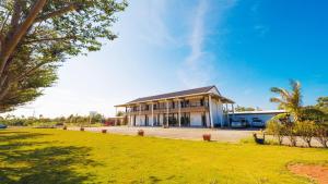 a building with a grassy field in front of it at Coconutpalm Home in Hengchun South Gate