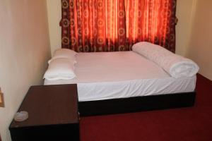 ein kleines Bett in einem Zimmer mit einem Tisch in der Unterkunft Pradhan House - Home Stay with Garden in Bhaktapur