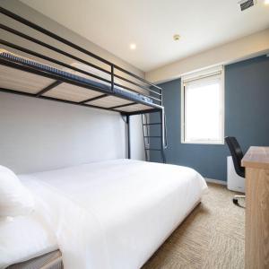 a bedroom with two bunk beds and a desk at Super Hotel Okinawa Nago in Nago +59 photos