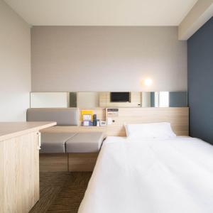 Un pat sau paturi într-o cameră la Super Hotel Okinawa Nago