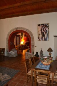 salon ze stołem i kamiennym kominkiem w obiekcie Agriturismo Malena w mieście Rossano