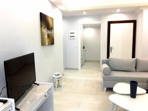 a living room with a couch and a television at Cavo Seaside Suites in Rethymno