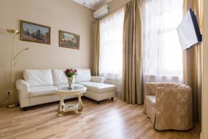 a living room with a couch and a table and a chair at Life Inn Apartments in Saint Petersburg