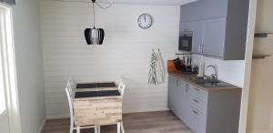 a kitchen with white walls and a table and a clock at Rättviks Golfby in Rättvik