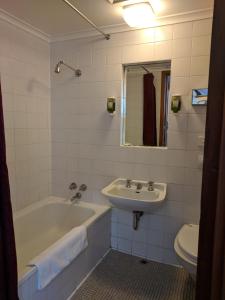 La salle de bains est pourvue d'une baignoire, d'un lavabo et de toilettes. dans l'établissement Prince Of Wales Hotel, à Hobart