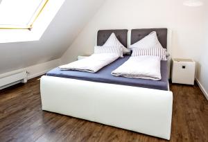 a white bed in a room with white walls at Lifestyle-Appartement Meersinn in Waren