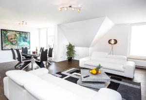 a living room with white furniture and a table at Lifestyle-Appartement Meersinn in Waren