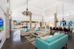 a living room with blue couches and a dining room at Coastal Elegance in Gold Coast