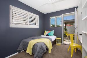 Un dormitorio con una cama y una silla amarilla. en Coastal Elegance, en Gold Coast 15 fotos más