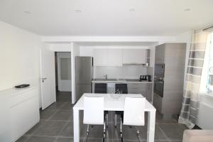 a kitchen with a white table and white chairs at Appartement T2 sur le port de sanary in Sanary-sur-Mer