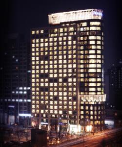 ein hohes Gebäude mit beleuchteten Fenstern in der Nacht in der Unterkunft Fraser Place Central Seoul in Seoul