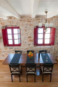 jadalnia z 2 stołami i krzesłami oraz 2 oknami w obiekcie Limeni Villa w mieście Limeni