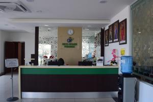 a lobby of a pharmacy with a counter with a clock at Hotel Desaru Penawar in Desaru