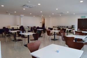 a dining room with tables and chairs and a chalkboard at Hotel Desaru Penawar in Desaru