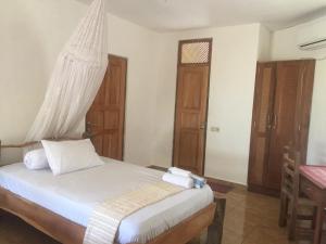 1 dormitorio con 1 cama con sábanas blancas y ventana en Oro Beach Houses, en Weetebula