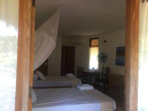 1 dormitorio con 2 camas y ventana en Oro Beach Houses, en Weetebula