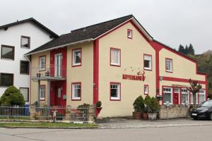 丁戈爾芬的住宿－Pension Kupferkanne，一座红色和白色的建筑,前面有一辆汽车