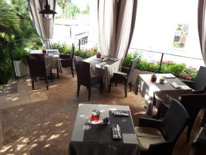 a restaurant with tables and chairs and a large window at Hotel Della Piccola Marina in Capri