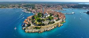an island in a body of water with boats at Apartments Javor in Rovinj