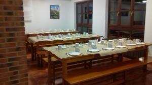 a row of tables with cups and plates on them at Albergue Cabrales in Carreña de Cabrales +26 photos