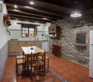 a kitchen with a table and chairs in a room at Casa de Aldea Vache in Naraval