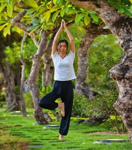 a woman doing yoga in front of a tree at Indochine Palace in Hue