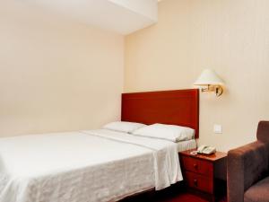 Tempat tidur dalam kamar di Cottage Inn Subang