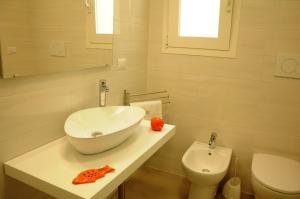 een badkamer met een wastafel en een toilet bij Punta Prosciutto GMA Tourism in Porto Cesareo +33 foto's