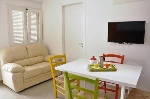 een woonkamer met een tafel en een bank bij Punta Prosciutto GMA Tourism in Porto Cesareo