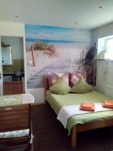 a bedroom with two beds and a painting of a beach at ElitasBB in Carnikava