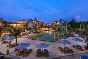 einen Luftblick auf einen Resortpool mit Stühlen und Sonnenschirmen in der Unterkunft Mai Khaolak Beach Resort & Spa - TUIBLUE Mai Khaolak in Khao Lak