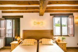 1 dormitorio con 2 camas y 2 ventanas en Posada La Charola, en Lamadrid