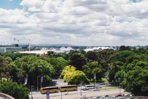 two yellow buses are parked in a parking lot at Quay West Suites Melbourne in Melbourne