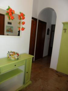 una stanza con un tavolo verde e fiori sul muro di La zucca violina a Ferrara