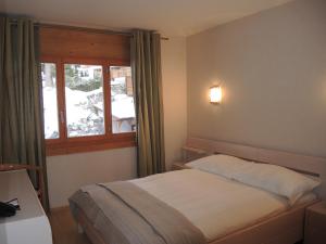 um quarto de hotel com uma cama e uma janela em Résidence RoyAlp - Appartement 22A em Villars-sur-Ollon