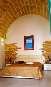 1 dormitorio con 1 cama grande y ventana en Borgoemare en Miggiano