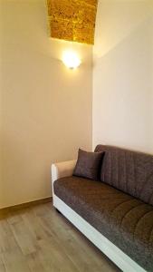 un sofá en una habitación con una luz en el techo en Borgoemare en Miggiano