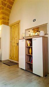 cocina con nevera blanca y puerta de madera en Borgoemare en Miggiano