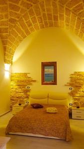 a bedroom with a large bed in a stone wall at Borgoemare in Miggiano