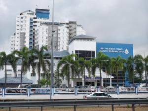 un'auto che guida su un'autostrada di fronte agli edifici di Cottage Inn Subang a Subang Jaya