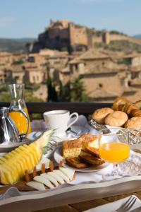 una mesa con una bandeja de alimentos para el desayuno y zumo de naranja en Alodia, en Alquézar