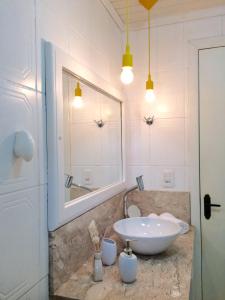 a bathroom with a sink and a mirror at Chalé Vale do Floresta in Gramado