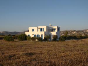 a large white house in a field of grass at Theophili in Zefiría