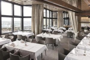 ein Restaurant mit weißen Tischen und Stühlen und Fenstern in der Unterkunft Hotel Stadt Breisach in Breisach am Rhein