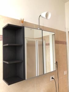 a bathroom with a mirror and a lamp at appartamenti vespucci 16 in Bardolino