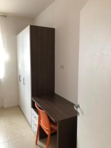 una scrivania nera con sedia arancione in una stanza di appartamenti vespucci 16 a Bardolino