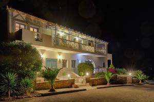 a large white house with a balcony at night at Kythira Golden Resort in Diakofti